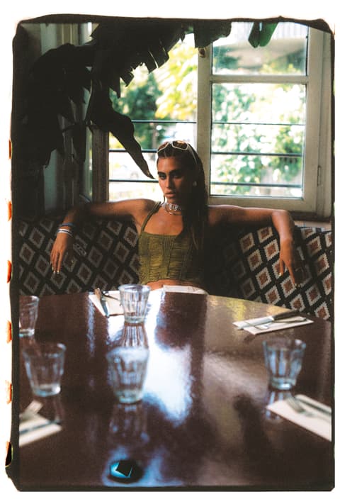 Dona asseguda en una taula de restaurant per a projecte marca de moda 16mm de Victor Lecha